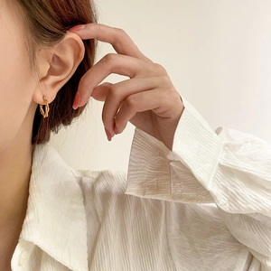 Minimalist gold twisted hoop earrings worn by a model for an elegant and refined look
