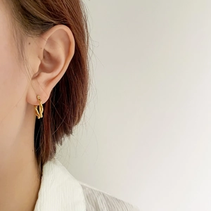 Close-up of golden twisted hoop earrings for women showing minimalist texture and design
