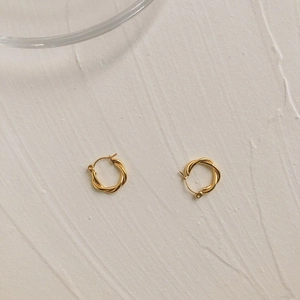 Close-up of golden twisted rope hoop earrings with polished spiral texture and clasp
