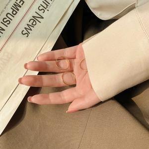 Close-up of three minimalist thin gold-plated stackable rings worn on a hand