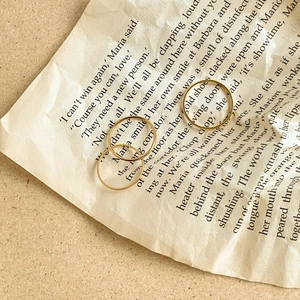 Minimalist gold plated titanium steel stackable rings set on vintage paper background