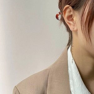 Close-up of elegant gold long chain drop earrings with geometric charm on model