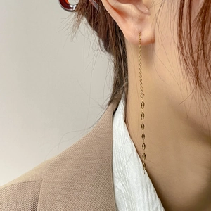 Elegant gold chain tassel earrings with rhombic sequins shown on a model in a formal suit