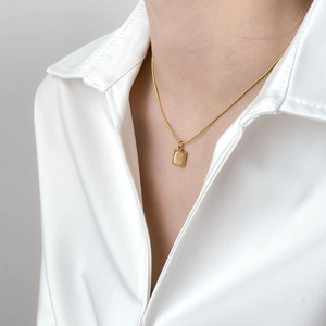 Détail du collier chaîne serpent dorée avec pendentif rectangulaire en pierre œil de chat