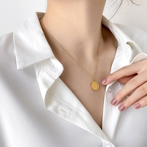 Elegant gold moon necklace with sparkling crystal worn on a white shirt model