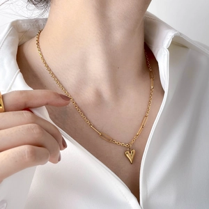 Elegante goldene Herzanhänger-Halskette an minimalistischer Kette zum weißen Hemd