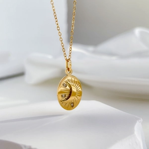Macro view of gold crescent moon and sun oval pendant with three sparkling zircon stones