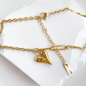 Nahaufnahme des goldenen Herzanhängers mit O-Kette und K18-Stempel auf dem Etikett