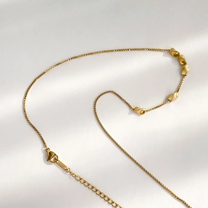 Macro view of K18 gold necklace showing lobster clasp and detailed chain craftsmanship