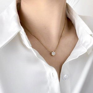 Minimalist gold necklace with a round sparkling zircon pendant on an elegant box chain