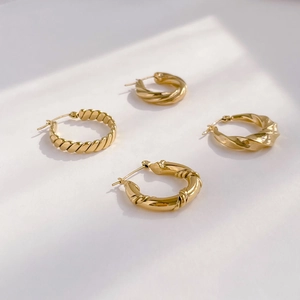 Set of four minimalist gold twisted hoop earrings with elegant geometric metal textures