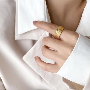 Macro detail of gold-plated woven wheat pattern on a vintage wide-band ring