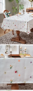 Close-up of colorful floral embroidery on a thick white polyester tablecloth fabric