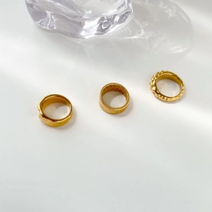 Detailed close-up of three gold-plated vintage textured rings with woven wheat patterns