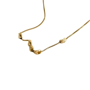 Gold box chain necklace featuring five irregular twisted beads in a minimalist design