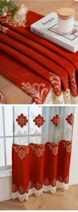 Detail of luxury red velvet curtain with golden floral embroidery and ivory lace trim