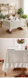 Detail of linen tablecloth featuring white ruffle hem edge and natural fabric texture