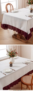 Close-up of beige linen tablecloth featuring elegant burgundy ruffled edge details