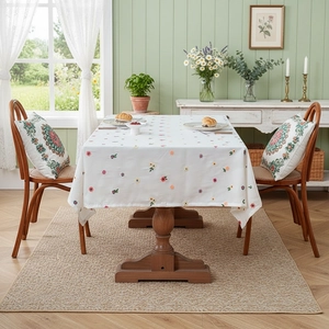 Floral embroidered tablecloth with matching cushions in a Nordic country style dining room