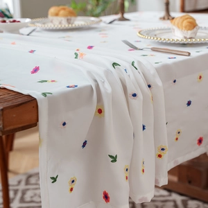 Elegant white floral embroidered tablecloth with colorful patterns on high-quality fabric