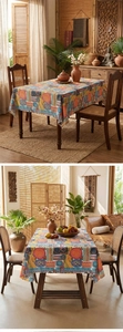 Detail view of ethnic tablecloth featuring complex geometric patterns in warm orange and blue