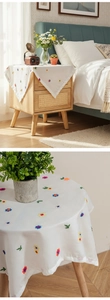 Close-up of floral embroidery on a white chiffon dust cover for small bedside tables