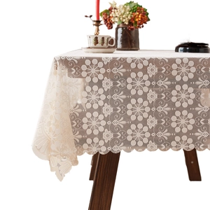 Elegant French style cream hollow floral lace tablecloth on a dark wood dining table