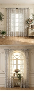 Close-up of light gray lace curtains with delicate white floral embroidery and sheer fabric
