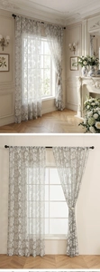 Close-up of grey lace curtain with white floral embroidery and semi-sheer mesh fabric