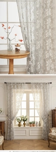 Detail of grey lace sheer curtain with white floral embroidery and semi-transparent texture