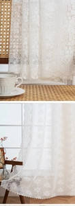 Macro detail of white floral lace curtain with vintage embroidery and wavy scalloped edges