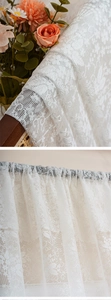 Macro detail of white floral lace curtain fabric with elegant crochet embroidery texture