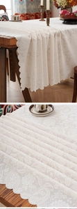 Detailed close-up of retro floral lace tablecloth with elegant scalloped wave edges