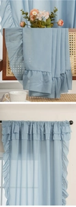 Detail of light blue ruffle sheer curtain with multi-layered edges and pleated top design