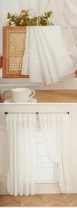 Detail of white ruffle sheer curtain in French style interior with soft lighting
