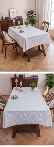Close-up of white damask jacquard tablecloth with elegant laser-cut scalloped edges