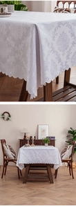 Detail of white damascus jacquard tablecloth with elegant scalloped edges on a wooden table