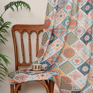 Bohemian style printed door curtain with orange and blue floral patterns on a wooden chair