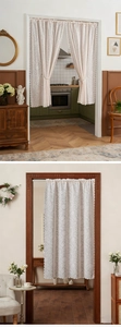 Detail eines Vintage-Spitzenvorhangs in Creme mit Blumenmuster und Wellenrand