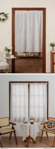 Detail einer weißen Spitzen-Türgardine mit Paisley-Mustern und gewelltem Randabschluss