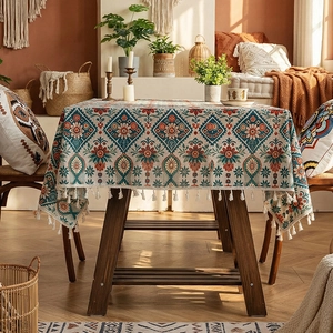 Bohemian style tablecloth with ethnic prints and white tassels in a cozy home setting