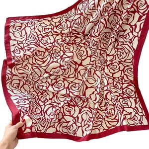 Elegant square silk scarf featuring a red rose floral pattern on a beige background