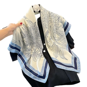 Vintage floral shawl in beige and blue draped over a black suit jacket on a hanger