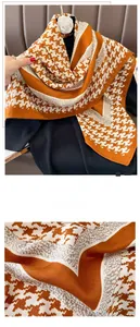 Detail of houndstooth scarf showing fine overlock stitching and soft knit fabric texture