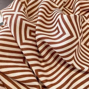 Close-up of brown and beige striped fabric with geometric pattern and woven texture