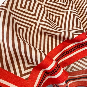 Detailed macro shot of striped scarf showing refined Greek Key texture and silk-like fabric