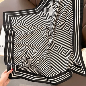 Detailed view of large black and white geometric pattern scarf with soft silk texture