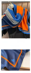Detail eines Seidenschals im Color-Block-Design mit Fischgrätmuster und feiner Naht