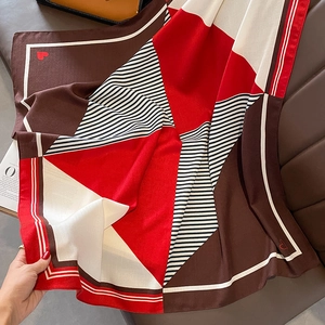 Detailaufnahme des bunten Seidenschals mit geometrischem Muster und roten Herzen