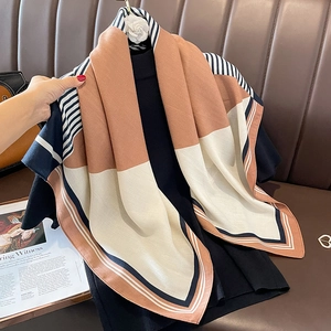 Modischer geometrischer Seidenschal mit Farbblock-Design in Beige und Navy auf Lederhintergrund